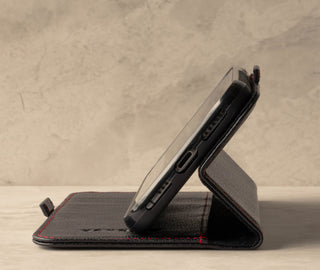 Demonstrating the stand function of the Black Leather (with Red Stitching) Stand Case for iPhone X/XS