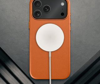 MagSafe charger attached to the Slimline Orange Leather Bumper Case for iPhone 17 Pro